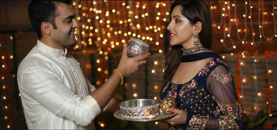 husband is offering water to his wife to break karwa chauth fast
