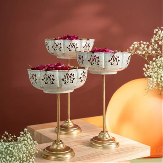 Decorative tiered stand with small bowls on a wooden surface against a warm brown background